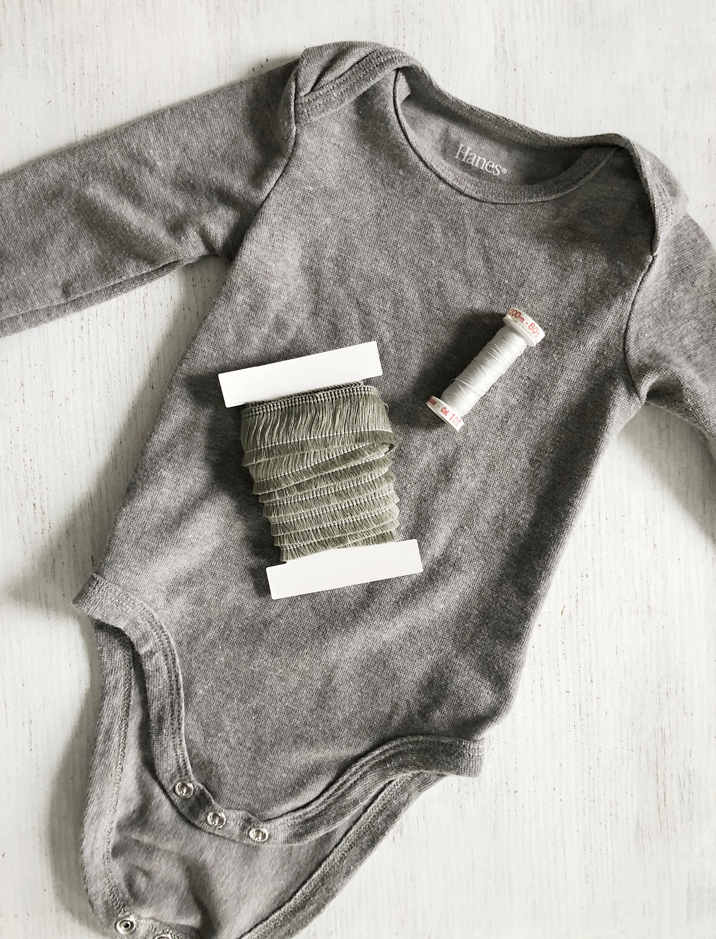 Easy DIY Fringe Trim Bodysuit For Baby /// By Design Fixation #baby #fringe #pompoms #diy #sewing